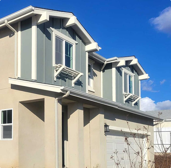 Aluminum rain gutters neatly installed along the edge of a residential roof, showcasing clean lines and durable materials for Seamless Gutter Installation San Diego.