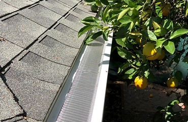 Close‑up view of multiple seamless gutter style samples installed along a roofline to show design variations and finishes, ideal for Seamless Gutter Installation San Diego visuals.